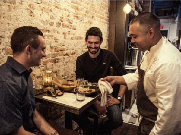 Bridges-Craft-Pizza-and-Wine-Bar-Indiana--head-chef-serves-food-to-friends-on-table